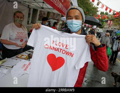 210912 -- VANCOUVER, le 12 septembre 2021 -- Un homme montre un T-shirt qu'il a acheté lors de l'événement Light Up Chinatown à Chinatown à Vancouver, Colombie-Britannique, Canada, le 11 septembre 2021. L'événement de deux jours organisé par Chinatown Business Improvement Association avec des spectacles, des camions de restauration, des lumières et des décorations. L’organisateur souhaite faire revenir les touristes et les acheteurs alors que les entreprises sont impactées par la pandémie COVID-19 et les crimes haineux anti-asiatiques au cours des derniers mois. Photo de /Xinhua CANADA-VANCOUVER-ILLUMINE CHINATOWN LiangxSen PUBLICATIONxNOTxINxCHN Banque D'Images