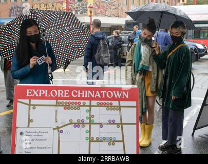 210912 -- VANCOUVER, le 12 septembre 2021 -- les gens regardent le répertoire des magasins lors de l'événement Light Up Chinatown à Chinatown à Vancouver, Colombie-Britannique, Canada, le 11 septembre 2021. L'événement de deux jours organisé par Chinatown Business Improvement Association avec des spectacles, des camions de restauration, des lumières et des décorations. L’organisateur souhaite faire revenir les touristes et les acheteurs alors que les entreprises sont impactées par la pandémie COVID-19 et les crimes haineux anti-asiatiques au cours des derniers mois. Photo de /Xinhua CANADA-VANCOUVER-ILLUMINE CHINATOWN LiangxSen PUBLICATIONxNOTxINxCHN Banque D'Images