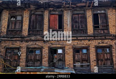 Srinagar Cachemire, Inde. 07 septembre 2023. Une femme regarde depuis une fenêtre de sa maison une procession pour marquer 'Krishna Janmashtami' à Srinagar. Janmashtami est un festival hindou qui marque l'anniversaire de naissance du seigneur hindou Krishna, l'un des dieux les plus populaires de l'hindouisme. Les hindous célèbrent Janmashtami en jeûnant, en chantant, en priant ensemble, en préparant et en partageant de la nourriture spéciale. Le 07 septembre 2023 à Srinagar Cachemire, Inde. (Image de crédit : © Firdous Nazir/eyepix via ZUMA Press Wire) USAGE ÉDITORIAL SEULEMENT! Non destiné à UN USAGE commercial ! Banque D'Images