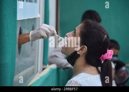 210918 -- GUWAHATI, 18 septembre 2021 -- Un agent de santé prélève un échantillon d'une femme pour un test COVID-19 dans la ville de Guwahati, dans l'État de l'Assam, au nord-est de l'Inde, le 18 septembre 2021. Le nombre de cas de COVID-19 en Inde est passé à 33 417 390 samedi, alors que 35 662 nouveaux cas ont été enregistrés au cours des dernières 24 heures à travers le pays, ont montré les dernières données du ministère fédéral de la Santé. Str/Xinhua INDIA-ASSAM-GUWAHATI-COVID-19-TEST JavedxDar PUBLICATIONxNOTxINxCHN Banque D'Images