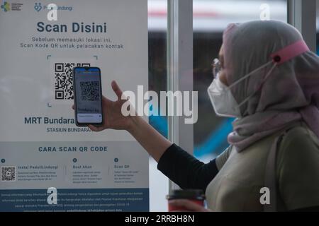 210923 -- JAKARTA, 23 septembre 2021 -- Une femme scanne le code QR avec une application mobile comme condition pour utiliser les transports publics pendant la pandémie de COVID-19 à Jakarta, Indonésie, le 23 septembre 2021. Le nombre de cas de COVID-19 en Indonésie a augmenté de 2 881 en un jour pour atteindre 4 201 559, avec un nombre de décès de 160 à 141.114, a déclaré jeudi le ministère de la Santé du pays. INDONÉSIE-JAKARTA-COVID-19-CAS VerixSanovri PUBLICATIONxNOTxINxCHN Banque D'Images
