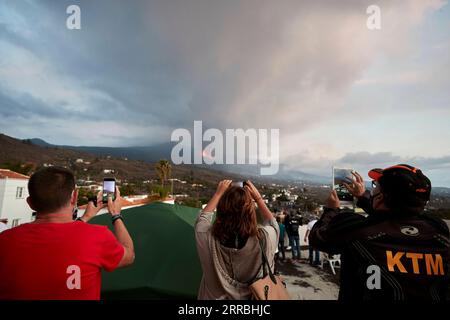 210924 -- LA PALMA, 24 septembre 2021 -- les gens regardent la scène de l'éruption volcanique du volcan Cumbre Vieja à la Palma, Espagne, 23 septembre 2021. Mercredi, l’Institut de Vulcanologie de l’INVOLCAN des îles Canaries a estimé que l’éruption pourrait durer 24-84 jours. Le volcan émet actuellement entre 6 140 et 11 500 tonnes de dioxyde de soufre SO2 chaque jour. Bien que six routes de l’île aient été fermées en raison de l’éruption, l’aéroport de la Palma reste ouvert avec 48 vols prévus pour jeudi. Néanmoins, la compagnie aérienne Tui a annulé tous ses vols vers l'île. ESPAGNE-LA PALMA-VOLCAN ENTRE EN ÉRUPTION Banque D'Images