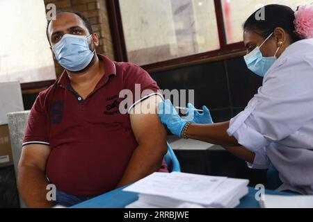 210926 -- LE CAIRE, le 26 septembre 2021 -- Un travailleur médical vaccine un homme au Centre de jeunesse Rod El Farag au Caire, Égypte, le 26 septembre 2021. Dimanche, l’Égypte a ouvert un centre de jeunesse dans chaque province pour permettre aux gens de recevoir le vaccin COVID-19, dans le but de faire avancer sa campagne de vaccination. EGYPTE-CAIRE-CENTRE DE JEUNESSE-VACCINATION AhmedxGomaa PUBLICATIONxNOTxINxCHN Banque D'Images