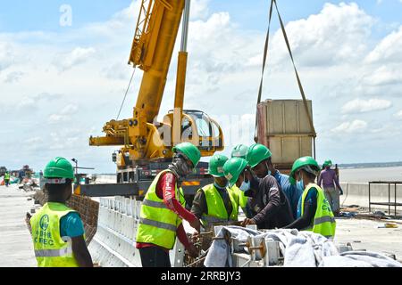 210926 -- MUNSHIGANJ, 26 septembre 2021 -- des gens travaillent sur un chantier de construction du projet de pont polyvalent Padma à Munshiganj, dans la banlieue de Dhaka, au Bangladesh, le 12 septembre 2021. Pour les Bangladais, un rêve devient réalité. L'histoire de traverser la puissante rivière Padma entre des dizaines de districts du sud du Bangladesh et la capitale de Dhaka uniquement par des ferries ou des bateaux est en passe de se terminer Le méga pont rail-route polyvalent baptisé Dream Padma Bridge of Bangladesh est presque achevé après que les travailleurs ont surmonté des tonnes d’obstacles, y compris les défis posés par la pandémie de COVID-19. Le câlin Banque D'Images