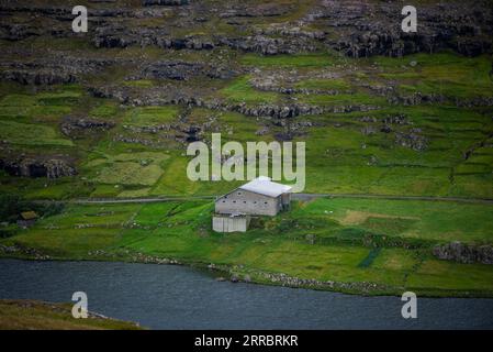 Une grande étable à moutons le long de la côte de la mer sur l'île d'Eysturoy dans les îles Féroé. Banque D'Images