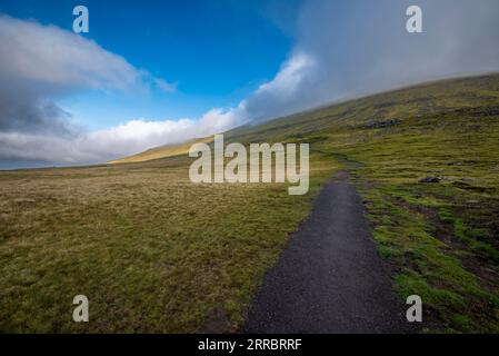 Un chemin de randonnée mène à une pente raide sur l'île d'Eysteroy dans les îles Féroé. Banque D'Images