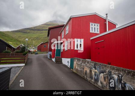 Une murale ludique de moutons jetant un œil autour d'une maison dans le village de Funningur sur l'île d'Eysturoy dans les îles Féroé. Banque D'Images