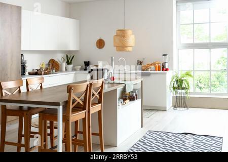 Intérieur de la cuisine légère avec des appareils modernes sur la table en bois Banque D'Images