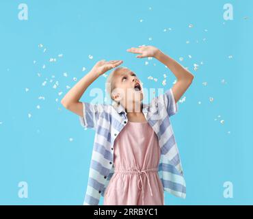 Fille choquée avec pop-corn volant sur fond bleu Banque D'Images