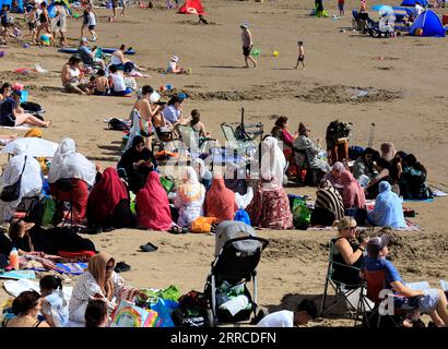 Les femmes des minorités ethniques pique-niquent sur la plage de Barry Island profitant de la journée la plus chaude de l'année. Sept. 2023. Banque D'Images