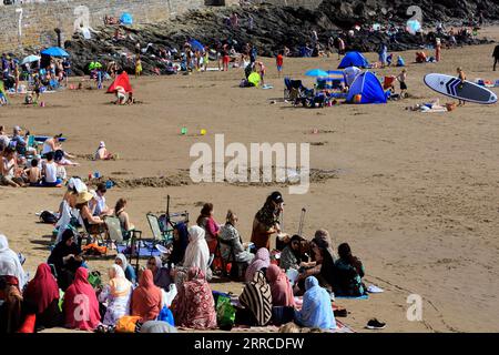 Les femmes des minorités ethniques pique-niquent sur la plage de Barry Island profitant de la journée la plus chaude de l'année. Sept. 2023. Banque D'Images