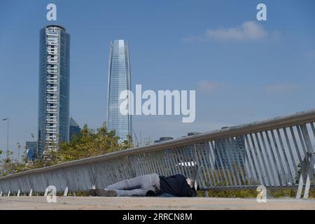 Santiago, Metropolitana, Chili. 7 septembre 2023. Un homme dort dans la rue devant les deux plus hauts bâtiments de Santiago, au Chili, la Tour Costanera et la Tour Titanium. (Image de crédit : © Matias Basualdo/ZUMA Press Wire) USAGE ÉDITORIAL SEULEMENT! Non destiné à UN USAGE commercial ! Banque D'Images