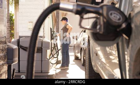 211115 -- LOS ANGELES, le 15 novembre 2021 -- Une femme se tient à côté d'une pompe à essence dans une station-service de Los Angeles, Californie, États-Unis, le 15 novembre 2021. Le prix moyen de l'essence en Californie a atteint 4,682 dollars américains le gallon lundi, établissant un nouveau record pour l'État américain le plus peuplé pour une deuxième journée consécutive. Selon l'American automobile Association AAA, le prix moyen de l'essence ordinaire était de 4,676 dollars américains par gallon dimanche, ce qui a déjà battu le précédent record de l'État de 4,671 dollars pour l'essence ordinaire établi en octobre 2012. Photo de /Xinhua U.S.-LOS ANG Banque D'Images