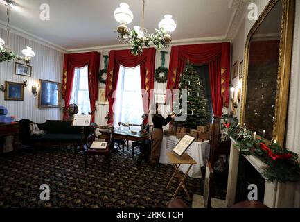 211117 -- LONDRES, le 17 novembre 2021 -- Un membre du personnel travaille au Charles Dickens Museum, décoré pour Noël, à Londres, en Grande-Bretagne, le 16 novembre 2021. Le musée Charles Dickens donne un aperçu de la façon dont Noël a été célébré par l'auteur victorien. Le musée est situé au 48 Doughty Street, maison londonienne de Dickens de 1837 à 1839. Alors qu'il vivait à Doughty Street, Dickens a fini d'écrire les Pickwick Papers, a écrit Nicholas Nickleby et surtout Oliver Twist. BRITAIN-LONDRES-CHARLES DICKENS MUSEUM LixYing PUBLICATIONxNOTxINxCHN Banque D'Images