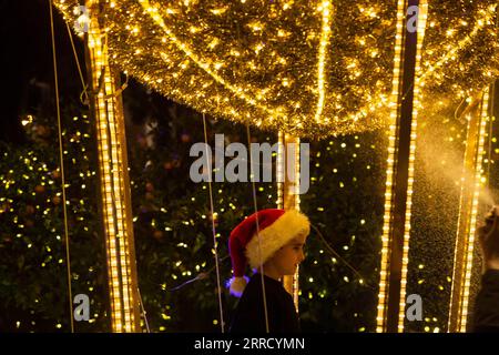 211123 -- ATHÈNES, le 23 novembre 2021 -- Un enfant est vu avec des lumières décoratives sur la place Syntagma à Athènes, en Grèce, le 23 novembre 2021. La saison des fêtes a débuté mardi soir à Athènes. GRÈCE-ATHÈNES-ARBRE DE NOËL-ÉCLAIRAGE MariosxLolos PUBLICATIONxNOTxINxCHN Banque D'Images