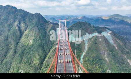 211130 -- GUIDING, 30 novembre 2021 -- une photo aérienne prise le 30 novembre 2021 montre le pont de Yangbaoshan lors d'un essai de charge statique dans le comté de Guiding, dans la province du Guizhou du sud-ouest de la Chine. Le pont de Yangbaoshan a effectué un essai de charge statique mardi. Quarante-huit gros camions transportant un total de 1 680 tonnes de marchandises ont été garés sur le pont pour tester la qualité de construction et les propriétés mécaniques de la structure du pont. Avec une travée principale de 650 mètres, le grand pont, qui fait partie de l'autoroute Guiyang-Huangping, s'étend sur 1 112 mètres de long. Photo de /Xinhua CHINA-GUIZHOU-YANGBAOSHAN BR Banque D'Images