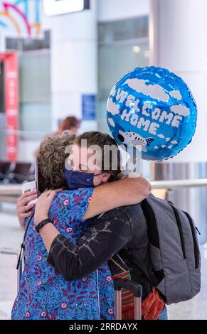 211215 -- SYDNEY, le 15 décembre 2021 -- Une femme accueille un passager de l'étranger à l'aéroport de Sydney, à Sydney, Australie, le 15 décembre 2021. Depuis décembre 15, les étudiants étrangers et les travailleurs qualifiés ont été autorisés à entrer en Australie pour la première fois depuis mars 2020, sous réserve des exigences de quarantaine dans leur État ou territoire d'arrivée. AUSTRALIE-INT L FRONTIÈRE-ÉTUDIANTS ET TRAVAILLEURS QUALIFIÉS-OUVERT BAIXXUEFEI PUBLICATIONXNOTXINXCHN Banque D'Images