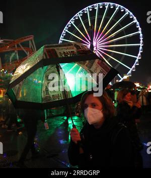 211225 -- LONDRES, le 25 décembre 2021 -- Une femme masquée marche dans Hyde Park Winter Wonderland la veille de Noël à Londres, Grande-Bretagne, le 24 décembre 2021. La Grande-Bretagne a signalé 122 186 autres cas de coronavirus au cours de la dernière période de 24 heures, dépassant 120 000 cas quotidiens pour la première fois depuis le début de la pandémie, selon les chiffres officiels publiés vendredi. UK-LONDRES-LA VEILLE DE NOËL-COVID-19 LixYing PUBLICATIONxNOTxINxCHN Banque D'Images