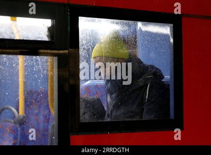 211225 -- LONDRES, le 25 décembre 2021 -- Un homme masqué est vu dans un bus la veille de Noël à Londres, en Grande-Bretagne, le 24 décembre 2021. La Grande-Bretagne a signalé 122 186 autres cas de coronavirus au cours de la dernière période de 24 heures, dépassant 120 000 cas quotidiens pour la première fois depuis le début de la pandémie, selon les chiffres officiels publiés vendredi. UK-LONDRES-LA VEILLE DE NOËL-COVID-19 LixYing PUBLICATIONxNOTxINxCHN Banque D'Images