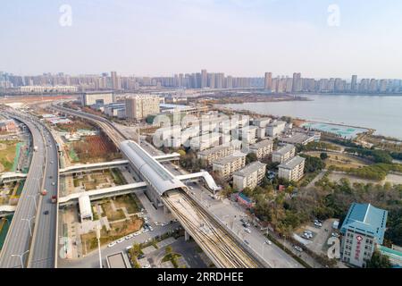 211226 -- WUHAN, 26 décembre 2021 -- une photo aérienne prise le 26 décembre 2021 montre la station de médecine chinoise de l'Université de Hubei de la ligne 5 du métro à Wuhan, dans la province du Hubei en Chine centrale. Trois lignes ferroviaires urbaines à Wuhan ont ouvert au public dimanche - la ligne 5, la deuxième phase de la ligne 6, et la ligne 16 Hannan, d'une longueur totale de 75,2 km La ligne 5 est la première ligne de métro entièrement automatisée de Wuhan. La ligne 16 est construite le long du fleuve Yangtze, avec la station la plus haute se dressant à 30 mètres, offrant aux passagers une belle vue. La longueur totale des rails de métro en service à Wuhan a atteint 435 km. Photo b. Banque D'Images