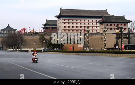 211228 -- XI AN, le 28 décembre 2021 -- Un livreur est vu dans une rue vide près de la porte Yongning à Xi an, dans la province du Shaanxi au nord-ouest de la Chine, le 28 décembre 2021. Les autorités de Xi an ont renforcé les mesures de contrôle et de prévention des épidémies à partir de lundi, ordonnant à tous les résidents de rester à l'intérieur et de rester à l'écart des rassemblements, sauf lorsqu'ils passent des tests d'acide nucléique. CHINE-SHAANXI-XI AN-COVID-19-PRÉVENTION ET CONTRÔLE CN TAOXMING PUBLICATIONXNOTXINXCHN Banque D'Images