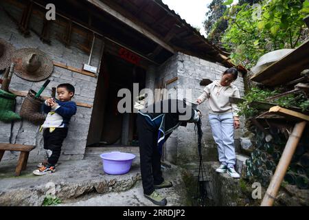 211230 -- RONGSHUI, le 30 décembre 2021 -- Liang Yuanhua R aide sa mère Liang Yingmi à se laver les cheveux dans le village de Wuying, à la frontière entre la région autonome de Guangxi Zhuang du sud de la Chine et la province de Guizhou du sud-ouest de la Chine, le 11 décembre 2021. Wuying Village est un hameau de minorité ethnique Miao qui se niche confortablement dans les montagnes imposantes qui s'étendent à travers la frontière entre Guangxi et Guizhou. Les habitants de la région souffrent depuis des années des terres arides, de l'environnement naturel rude et des transports peu pratiques. Les habitants de Wuying ont ébranlé la pauvreté en 2020. En 2021, avec l'aide au couplage pour r Banque D'Images