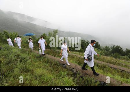 220104 -- PÉKIN, le 4 janvier 2022 -- Wang Jinhui 1st R et ses collègues marchent sur une route de montagne en juillet 2020. POUR ALLER AVEC à travers la Chine : les équipes médicales des montagnes de Pékin CHINE-BEIJING-DA ANSHAN-MEDICAL ÉQUIPES CN Xinhua PUBLICATIONxNOTxINxCHN Banque D'Images