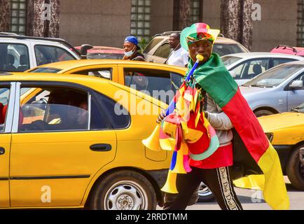 220108 -- YAOUNDÉ, 8 janvier 2022 -- la photo prise le 4 janvier 2022 montre un jeune homme dans la rue vendant des gadgets aux couleurs du drapeau camerounais à Yaoundé, capitale du Cameroun. Coupe d’Afrique des Nations APRÈS le football, une compétition biennale débutera ce dimanche à Yaoundé, capitale du Cameroun. Événement sportif important sur le continent, il a attiré l’attention de tous les fans camerounais. En prélude à la cérémonie d’ouverture, une ambiance de ce concours pouvait déjà être remarquée dans la ville. Photo de /Xinhua SPCAMEROON-YAOUNDE-FOOTBALL-COUPE D'AFRIQUE DES NATIONS-À VENIR Kepseu PUBL Banque D'Images