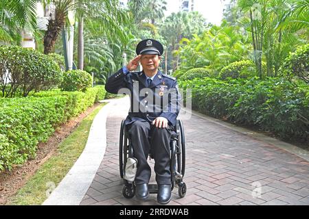 220109 -- NANNING, 9 janvier 2022 -- une photo prise le 6 janvier 2022 montre Tan Jianyong saluant à Nanning, dans la région autonome de Guangxi Zhuang, dans le sud de la Chine. Tan Jianyong est un policier de 49 ans à Nanning. En 1998, trois ans après être devenu policier, Tan a été abattu d'une balle dans la poitrine par un tireur et a été paralysé de la poitrine vers le bas. Encouragé par sa famille, ses collègues et ses amis, Tan a été sorti du bourbier de la dépression. Il a progressivement retrouvé la capacité de prendre soin de lui-même et est retourné à son poste avec des politiques de soutien du travail. En dehors du travail, Tan s'est également impliqué dans la communauté, comme il est WIL Banque D'Images