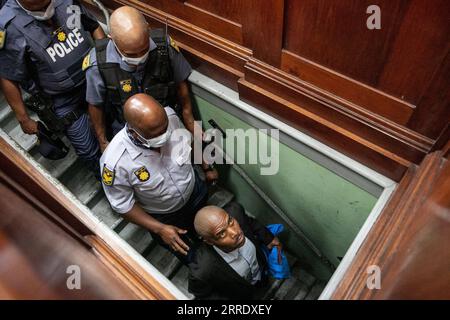 220111 -- LE CAP, le 11 janvier 2022 -- Zandile Christmas Mafe 1st R quitte une salle d'audience du tribunal de première instance du Cap, au Cap, en Afrique du Sud, le 11 janvier 2022. Le parquet sud-africain a ajouté une accusation d'acte de terrorisme à Mafe, qui est soupçonné d'avoir mis le feu au Parlement, ce qui a finalement détruit les bâtiments du Parlement, a entendu mardi le tribunal. Mafe, 49 ans, avait été accusé de démolition de maison avec intention de voler et de vol, de deux chefs d’incendie criminel, de possession d’un engin explosif et de destruction d’une infrastructure essentielle. AFRIQUE DU SUD-CAPE TOWN-PARLEMENT INCENDIE-SUSPECT-CHARGE LYUXTIANR Banque D'Images