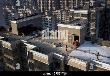 220114 -- XI AN, le 14 janvier 2022 -- une photo aérienne prise le 14 janvier 2022 montre des résidents jouant au badminton sur un toit dans un quartier résidentiel de Xi an, dans la province du Shaanxi, au nord-ouest de la Chine. Avec des cas à un chiffre pendant trois jours consécutifs et moins de zones à risque moyen de COVID-19, la situation épidémique globale de Xian s améliore. CHINA-SHAANXI-XI AN-EPIDEMIC SITUATION-AMÉLIORER CN TAOXMING PUBLICATIONXNOTXINXCHN Banque D'Images