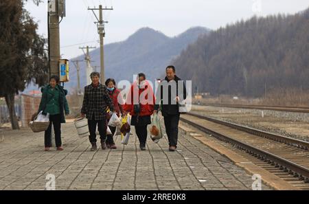 220117 -- DANDONG, 17 janvier 2022 -- les villageois transportant leurs marchandises se préparent à monter à bord d'un train lent à la gare de Shicheng dans la ville de Fengcheng, province du Liaoning, au nord-est de la Chine, le 15 janvier 2022. Les trains nos 4317 et 4318 sont des trains lents qui circulent entre Tonghua de la province de Jilin et Dandong de la province de Liaoning dans le nord-est de la Chine. À l’approche du nouvel an lunaire, les autorités ferroviaires locales ont organisé des marchés à bord qui permettent aux villageois vivant le long de la route des trains de vendre des marchandises aux passagers sans quitter les wagons. CHINA-LIAONING-DANDONG-ON-BOARD MARCHÉ CN YANGXQING BLI Banque D'Images