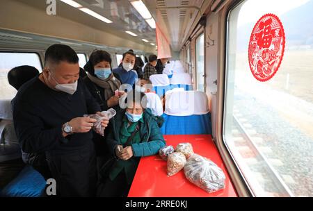 220117 -- DANDONG, le 17 janvier 2022 -- des passagers achètent des marchandises vendues par des villageois locaux à bord du train n° 4318 dans la province du Liaoning, dans le nord-est de la Chine, le 15 janvier 2022. Les trains nos 4317 et 4318 sont des trains lents qui circulent entre Tonghua de la province de Jilin et Dandong de la province de Liaoning dans le nord-est de la Chine. À l’approche du nouvel an lunaire, les autorités ferroviaires locales ont organisé des marchés à bord qui permettent aux villageois vivant le long de la route des trains de vendre des marchandises aux passagers sans quitter les wagons. CHINE-LIAONING-DANDONG-ON-BOARD MARCHÉ CN YANGXQING PUBLICATIONXNOTXINXCHN Banque D'Images