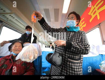 220117 -- DANDONG, le 17 janvier 2022 -- Un villageois pèse un morceau de viande sur le train n° 4318 dans la province du Liaoning au nord-est de la Chine, le 15 janvier 2022. Les trains nos 4317 et 4318 sont des trains lents qui circulent entre Tonghua de la province de Jilin et Dandong de la province de Liaoning dans le nord-est de la Chine. À l’approche du nouvel an lunaire, les autorités ferroviaires locales ont organisé des marchés à bord qui permettent aux villageois vivant le long de la route des trains de vendre des marchandises aux passagers sans quitter les wagons. CHINE-LIAONING-DANDONG-ON-BOARD MARCHÉ CN YANGXQING PUBLICATIONXNOTXINXCHN Banque D'Images