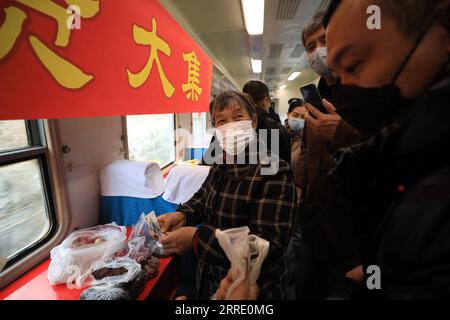 220117 -- DANDONG, le 17 janvier 2022 -- des passagers achètent des marchandises à bord du train n° 4318 dans la province du Liaoning, dans le nord-est de la Chine, le 15 janvier 2022. Les trains nos 4317 et 4318 sont des trains lents qui circulent entre Tonghua de la province de Jilin et Dandong de la province de Liaoning dans le nord-est de la Chine. À l’approche du nouvel an lunaire, les autorités ferroviaires locales ont organisé des marchés à bord qui permettent aux villageois vivant le long de la route des trains de vendre des marchandises aux passagers sans quitter les wagons. CHINE-LIAONING-DANDONG-ON-BOARD MARCHÉ CN YANGXQING PUBLICATIONXNOTXINXCHN Banque D'Images