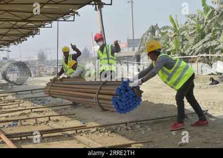 220122 -- DHAKA, le 22 janvier 2022 -- Un ingénieur chinois 2nd R donne des instructions alors que des ouvriers construisent une autoroute qui contourne Dhaka, capitale du Bangladesh, le 4 janvier 2022. Les travaux sur une entreprise commune sino-bangladaise visant à construire une autoroute transformationnelle contournant Dhaka, la capitale du Bangladesh, sont bien avancés. La méga autoroute reliera les ceintures industrielles autour de Dhaka au port maritime de Chattogram et à la région nord-est de Sylhet, contournant la capitale encombrée. Environ 400 millions de dollars américains seront dépensés pour l'artère à quatre voies. POUR ALLER AVEC la Chine méga-technologie conduit Bangladesh méga autoroute BANGLA Banque D'Images