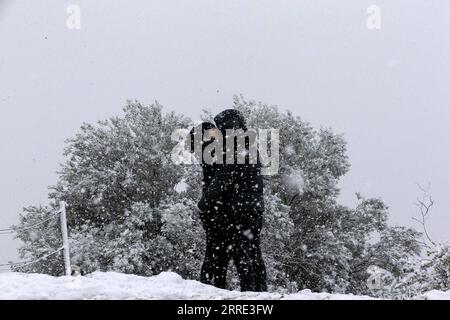 220124 -- ATHÈNES, le 24 janvier 2022 -- Un couple s'embrasse dans la neige à Athènes, en Grèce, le 24 janvier 2022. Un front froid intense balayait la Grèce lundi, provoquant des perturbations dans les transports et des coupures de courant pendant plusieurs heures dans de nombreuses régions, ont indiqué les autorités locales. GRÈCE-ATHÈNES-NEIGE MariosxLolos PUBLICATIONxNOTxINxCHN Banque D'Images