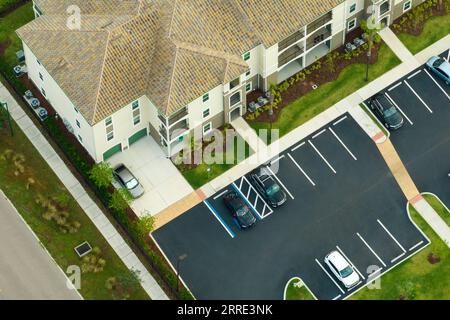 Vue aérienne des voitures garées sur les places de stationnement à l'immeuble d'appartements américain dans le quartier résidentiel de Floride. Condos familiaux neufs comme exemple de logement Banque D'Images