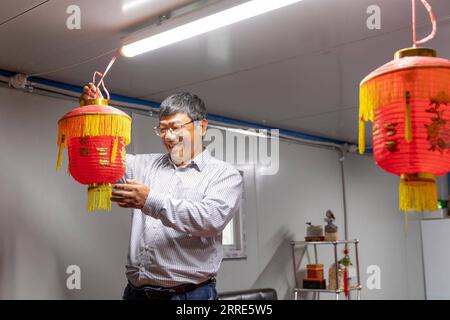 220130 -- CANBERRA, le 30 janvier 2022 -- Wu Penghui, propriétaire d'une ferme de champignons, décore son bureau de lanternes pour accueillir le Festival du printemps à Canberra, en Australie, le 28 janvier 2022. Lorsque le Festival du printemps arrive alors que l’Australie est en proie au COVID-19, la façon dont les gens célèbrent changera certainement. Cependant, pour les Chinois d'outre-mer, la décoration du nouvel an, les boulettes et le mal du pays sont comme d'habitude. POUR ALLER AVEC la caractéristique : couplets, boulettes et souhaits, les Chinois d'outre-mer célèbrent les Jeux olympiques d'hiver et le Festival du printemps à Canberra photo par /Xinhua AUSTRALIA-CANBERRA-SPRING FESTIVAL-OVERSEAS CHINESE-CELE Banque D'Images