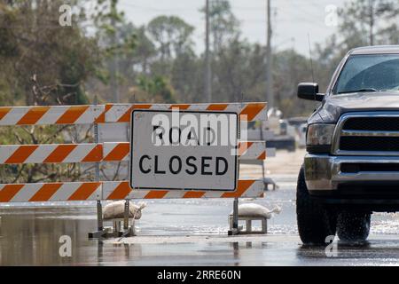 Rue inondée en Floride après les pluies d'ouragan avec des panneaux de routes fermées bloquant la conduite des voitures. La sécurité des transports en cas de catastrophe naturelle Banque D'Images