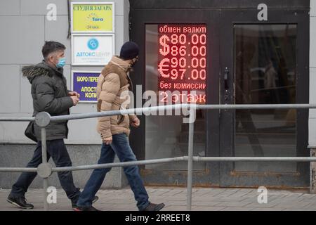 220224 -- MOSCOU, le 24 février 2022 -- les gens passent devant un tableau électronique montrant les taux de change à Moscou, Russie, le 24 février 2022. Le taux de change du rouble russe a plongé après le lancement des opérations militaires russes dans le Donbass. RUSSIE-MOSCOU-ROUBLE ÉCHANGE-EFFONDREMENT BaixXueqi PUBLICATIONxNOTxINxCHN Banque D'Images