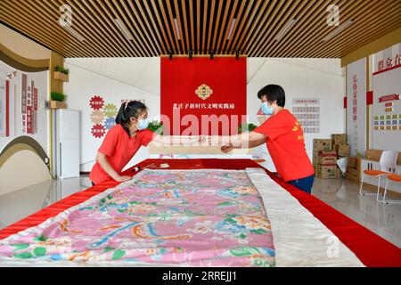 220304 -- TIANJIN, le 4 mars 2022 -- Un jeune handicapé L fabrique une courtepointe pour un villageois dans la rue Koudong du district de Baodi, dans le nord de la Chine à Tianjin, le 18 mai 2021. Dans un complexe spécial de la ville de Shigezhuang, district de Baodi, 49 jeunes handicapés âgés en moyenne de moins de 23 ans travaillent et vivent ici. Le retard mental, la déficience visuelle et d'autres handicaps les ont autrefois rendus inférieurs. Cependant, avec l'aide de Tian Lichao, ils deviennent de plus en plus confiants. Un jour en 2016, Tian Lichao a rencontré une fille perdue avec un handicap intellectuel sur la route. Après avoir parlé avec le principal de l'espèce Banque D'Images