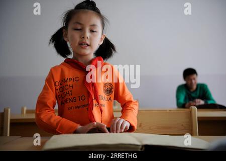 220316 -- YINCHUAN, 16 mars 2022 -- Ma Yifei lit un livre en braille pendant un cours à Yinchuan, dans la région autonome hui de Ningxia, au nord-ouest de la Chine, le 21 mai 2013. Pour Ma Yifei, une fillette de 16 ans ayant une déficience visuelle, le morceau de violon de la chanson thème de Beijing 2022, Snowflake, qu’elle a joué lors de la cérémonie de clôture des Jeux paralympiques d’hiver de Beijing 2022, est son meilleur cadeau pour les paralympiens du monde entier. Ma, étudiante en deuxième année au lycée d'éducation spéciale de Ningxia dans la région autonome hui de Ningxia, dans le nord-ouest de la Chine, a perdu la vue à l'âge de deux ans par maladie. Avec l'espoir que la musique le ferait Banque D'Images