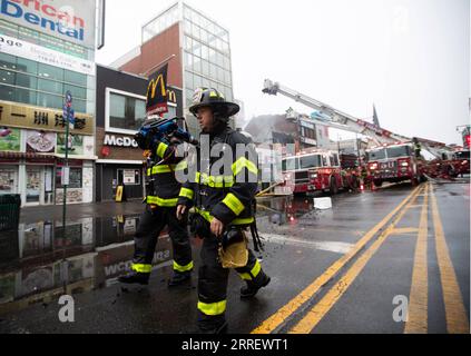 220317 -- NEW YORK, le 17 mars 2022 -- les pompiers travaillent sur le site de l'incendie à Flushing, à New York, aux États-Unis, le 17 mars 2022. Un bâtiment commercial dans Flushing Chinatown de New York a subi de graves dommages suite à un incendie de 5 alarmes jeudi matin. ETATS-UNIS-NEW YORK-IMMEUBLE COMMERCIAL-INCENDIE MAJEUR WANGXYING PUBLICATIONXNOTXINXCHN Banque D'Images