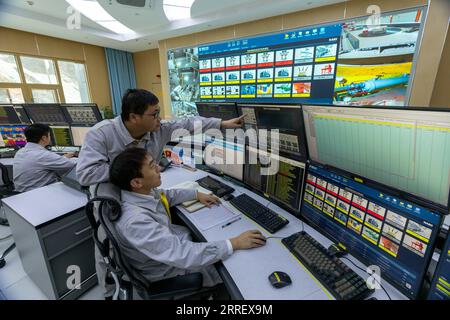 220318 -- YAJIANG, le 18 mars 2022 -- des membres du personnel surveillent le fonctionnement de la centrale hydroélectrique de Lianghekou sur le fleuve Yalong, dans la préfecture autonome tibétaine de Garze, dans le sud-ouest de la Chine, province du Sichuan, le 17 mars 2022. Avec la mise en service officielle de la dernière unité de production d’électricité de 500 000 kW, la centrale hydroélectrique de Lianghekou construite à une altitude moyenne de 3 000 mètres, la plus élevée de son genre en Chine, est entrée pleinement en service vendredi. Avec une capacité installée totale prévue de 3 millions de kW et un investissement approuvé de 66,5 milliards de yuans environ 10,5 milliards de dollars américains, la construction de TH Banque D'Images