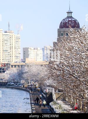 220319 -- TIANJIN, le 19 mars 2022 -- les gens se promènent le long de la rivière Haihe après la neige dans le nord de la Chine, Tianjin, le 19 mars 2022. CHINE-TIANJIN-SNOW SCENERY CN SunxFanyue PUBLICATIONxNOTxINxCHN Banque D'Images