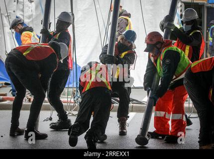 220319 -- VANCOUVER, le 19 mars 2022 -- les travailleurs poussent les poteaux de soutien pour élever le grand toit à sa position finale pour le spectacle Alegria du Cirque du Soleil à venir à Concord Pacific place à Vancouver, Colombie-Britannique, Canada, le 18 mars 2022. Plus de 60 travailleurs ont poussé plus de 100 poteaux de soutien pour élever la toile dans sa position finale afin d'installer l'emblématique Big Top - où aura lieu la scène principale du Cirque du Soleil. Photo de /Xinhua CANADA-VANCOUVER-CIRQUE DU SOLEIL-BIG TOP-RAISING LiangxSen PUBLICATIONxNOTxINxCHN Banque D'Images