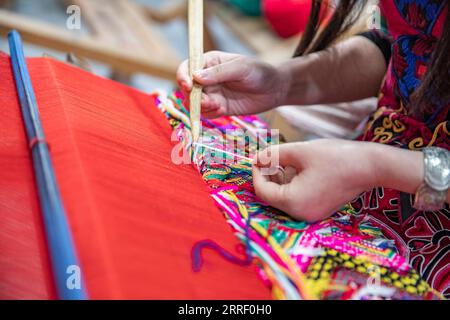 220322 -- CHONGQING, le 22 mars 2022 -- Une femme fabrique des produits en Xilankapu, qui est une sorte de brocart Tujia, dans un studio de la ville de Xiaonanhai du district de Qianjiang dans le sud-ouest de la Chine, Chongqing, le 22 mars 2022. Xilankapu, également connu sous le nom de tricot Floral Bedsweetings, a été inscrit au patrimoine culturel immatériel national en 2006. CHINE-CHONGQING-TUJIA BROCADE CN HuangxWei PUBLICATIONxNOTxINxCHN Banque D'Images