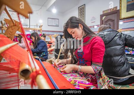 220322 -- CHONGQING, le 22 mars 2022 -- des femmes fabriquent des produits en Xilankapu, qui est une sorte de brocart Tujia, dans un studio de la ville de Xiaonanhai, dans le district de Qianjiang, dans le sud-ouest de la Chine, Chongqing, le 22 mars 2022. Xilankapu, également connu sous le nom de tricot Floral Bedsweetings, a été inscrit au patrimoine culturel immatériel national en 2006. CHINE-CHONGQING-TUJIA BROCADE CN HuangxWei PUBLICATIONxNOTxINxCHN Banque D'Images