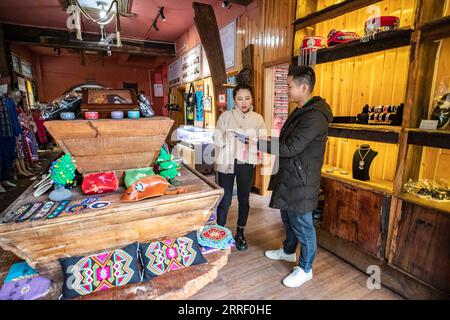 220322 -- CHONGQING, le 22 mars 2022 -- Un visiteur L sélectionne des produits de Xilankapu, qui est une sorte de brocart Tujia, exposés dans la ville de Xiaonanhai du district de Qianjiang dans le sud-ouest de la Chine à Chongqing, le 22 mars 2022. Xilankapu, également connu sous le nom de tricot Floral Bedsweetings, a été inscrit au patrimoine culturel immatériel national en 2006. CHINE-CHONGQING-TUJIA BROCADE CN HuangxWei PUBLICATIONxNOTxINxCHN Banque D'Images